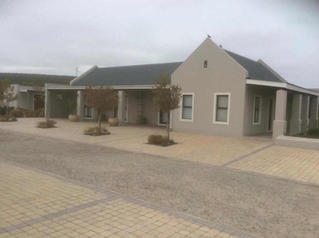 ein großes weißes Gebäude mit Auffahrt in der Unterkunft Longacre Olive & Vineyard Estate in Langebaan