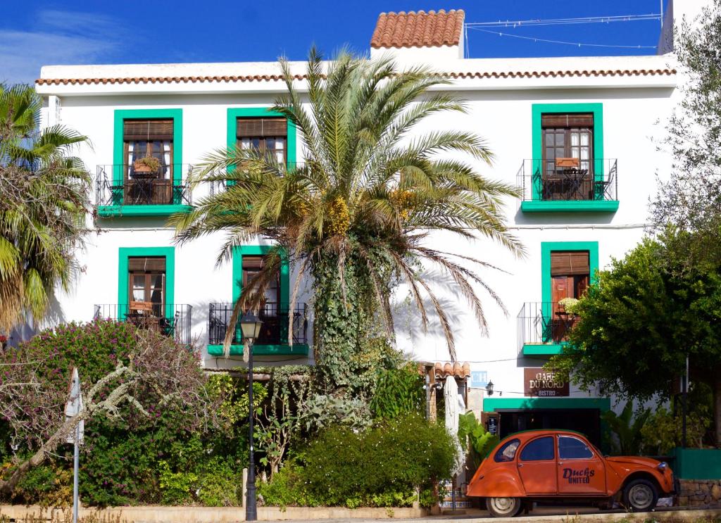 an orange car parked in front of a white building at Gare du Nord in Sant Joan de Labritja
