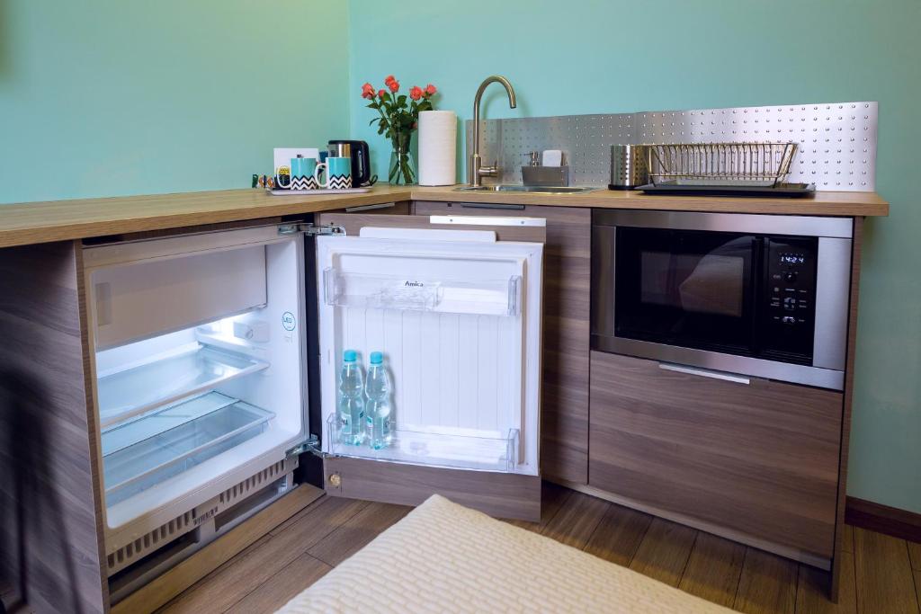W kuchni znajduje się otwarta lodówka i kuchenka mikrofalowa. w obiekcie Apartamenty Centrum w Piotrkowie Trybunalskim