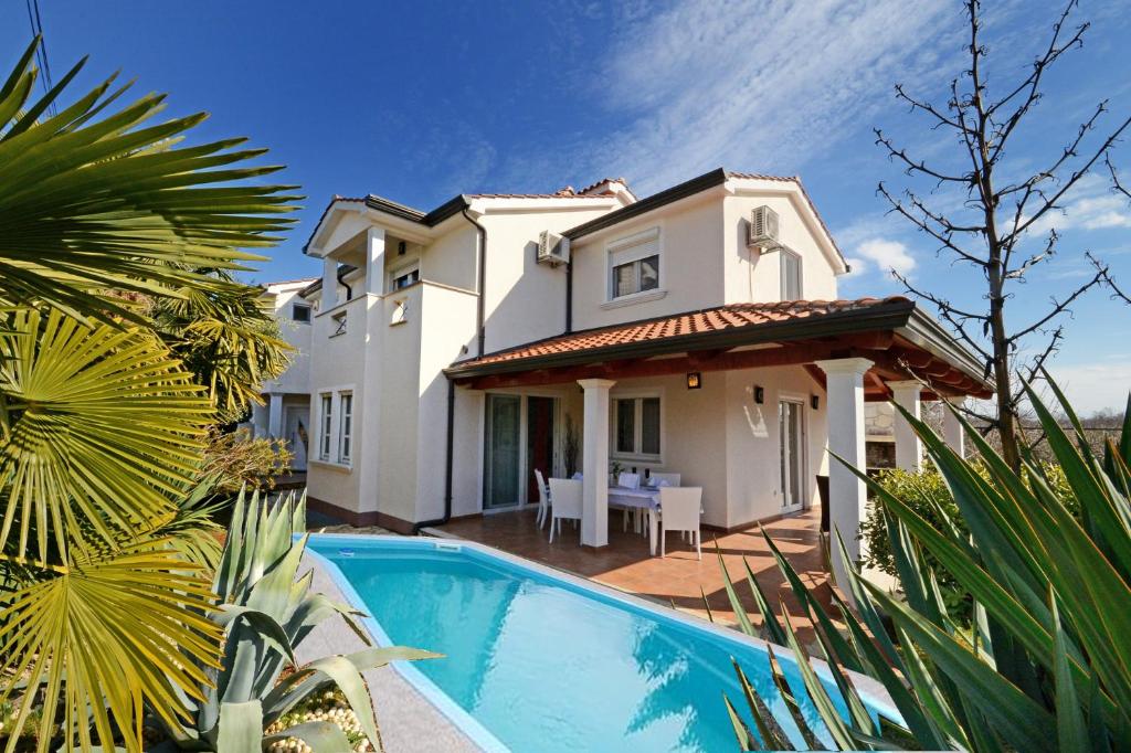 a villa with a swimming pool in front of a house at Villa Zare in Poreč