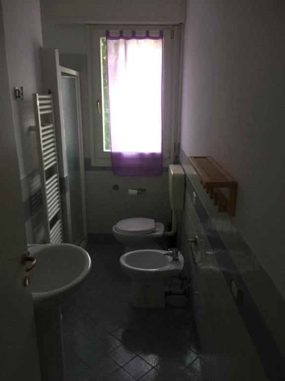 a bathroom with two sinks and a window and two toilets at Appartamento La Valle in Marina Romea