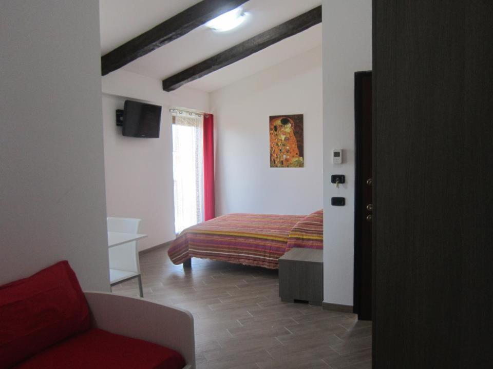 a bedroom with a bed and a red couch at B & B IL TRATTURO in San Pietro Avellana