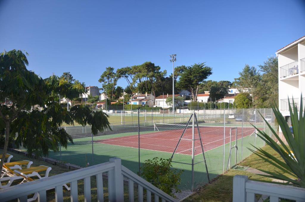 a tennis court with a net on a tennis court at Hotel et Spa Les Cleunes Oléron in Saint-Trojan-les-Bains