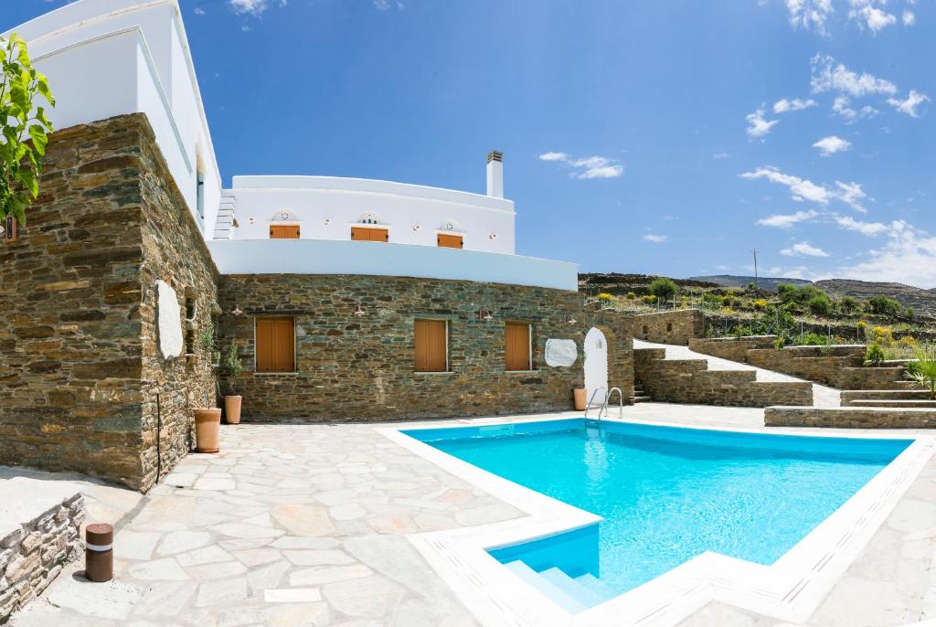a villa with a swimming pool in front of a building at Imarkellis Boutique Villas in Pánormos