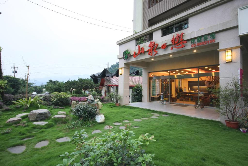 a restaurant with a lawn in front of a building at Shan Quan Zhi Lian Homestay in Datong