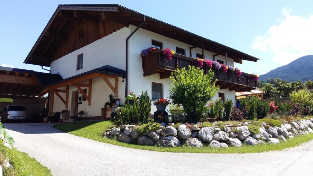 una casa con flores a un lado. en Ferienwohnungen Wimmer, en Bischofshofen