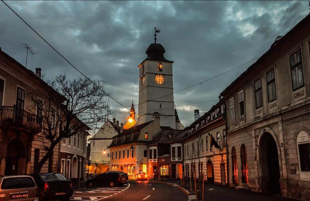 een gebouw met een klokkentoren in een stadsstraat bij Weidner Apartments in Sibiu