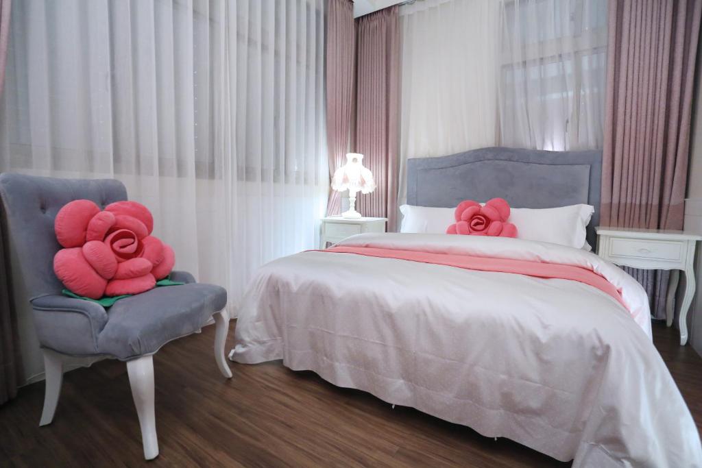 a bedroom with a bed and a chair with red flowers on it at Campestral Garden in Jiaoxi