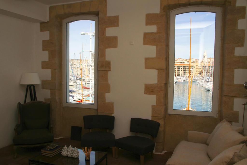 - un salon avec trois fenêtres offrant une vue sur le port dans l'établissement Mermoz, à Marseille