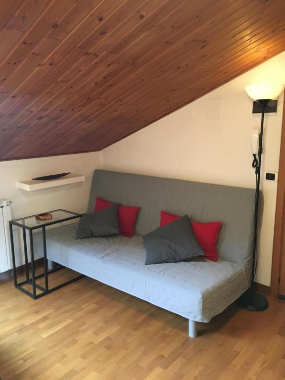 un sofá en una habitación con techo de madera en Happy House en Gubbio
