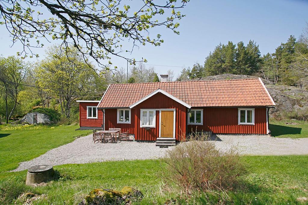 a red house with a picnic table in front of it at Ängsö Fishermans Cottage in Västerås