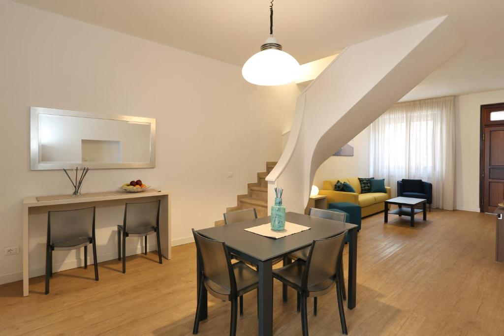 a dining room and living room with a table and chairs at Lupori House in Viareggio