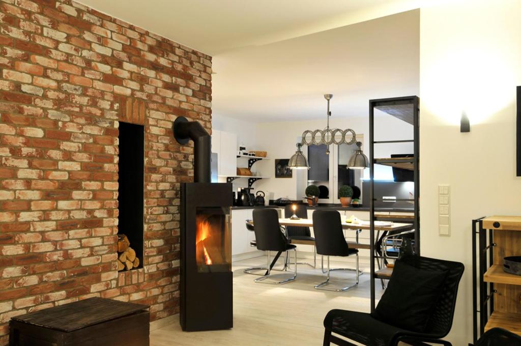 a living room with a brick wall and a fireplace at Villa Kiesel in Zempin