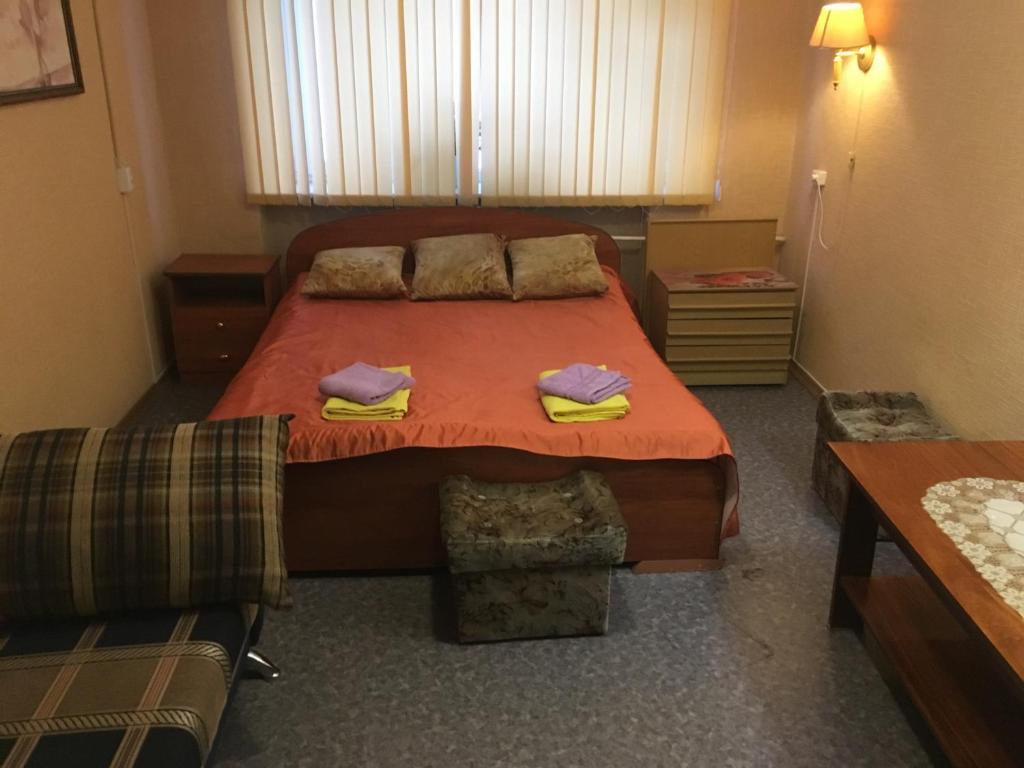 a bedroom with a bed with two towels on it at Apartment Vash Dom Vecher in Murmansk