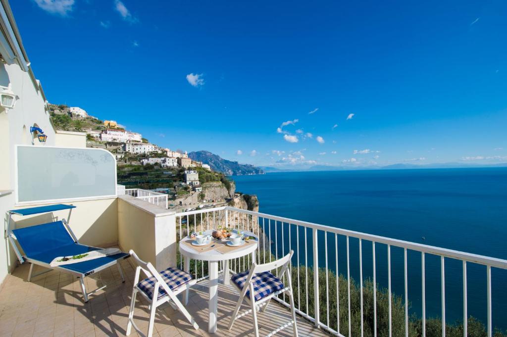 balcón con mesa y sillas y vistas al océano en Edera, en Amalfi
