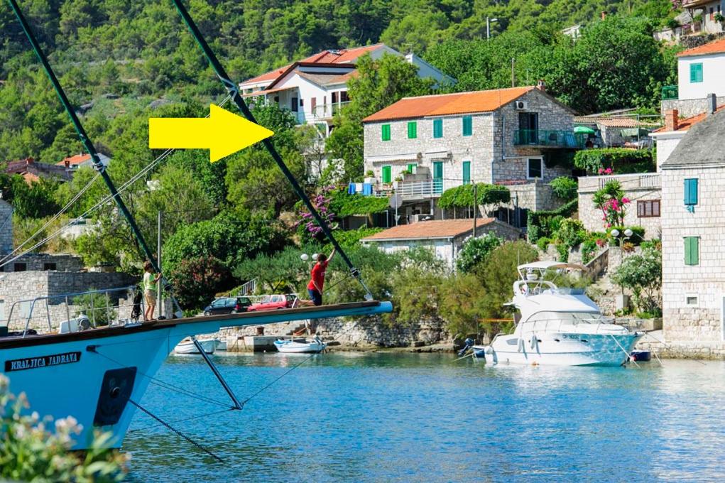 a boat in the water with a yellow arrow at Apartments Maestro in Stomorska