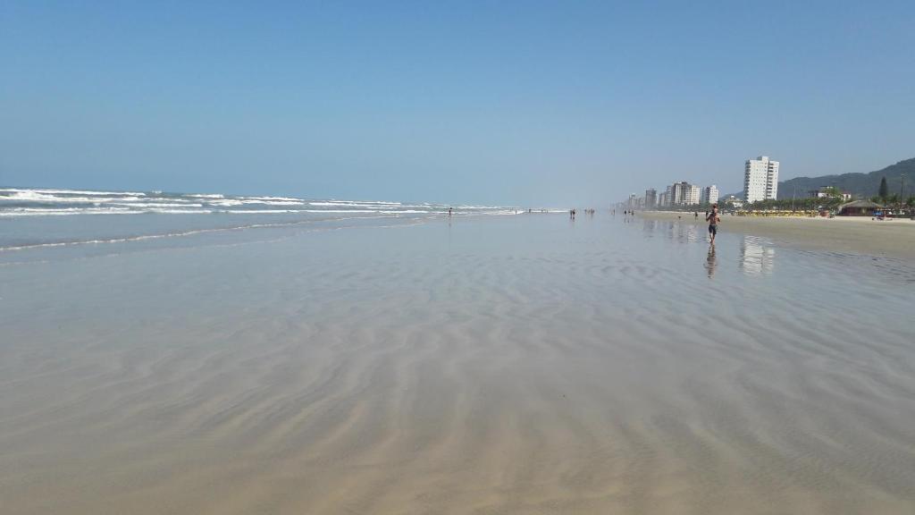 a person standing in the water on a beach at Apto Praia Grande in Praia Grande
