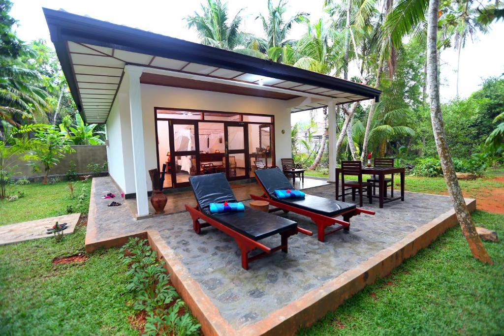 uma pequena casa com um pátio, uma mesa e cadeiras em Selnara Private Luxury Villa and Ayurveda Spa em Bentota