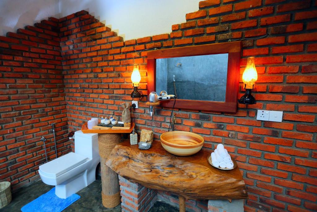 a bathroom with a wooden sink and a brick wall at Selnara Private Luxury Villa and Ayurveda Spa in Bentota