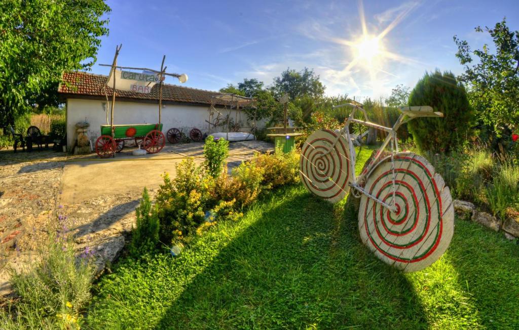 a garden with two garden sculptures in the grass at Levana Guest House in Bŭlgarevo