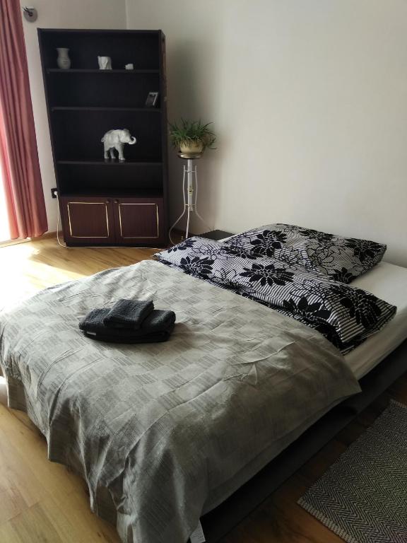 a bedroom with a bed with a black and grey bedspread at Veszprem city center in Veszprém