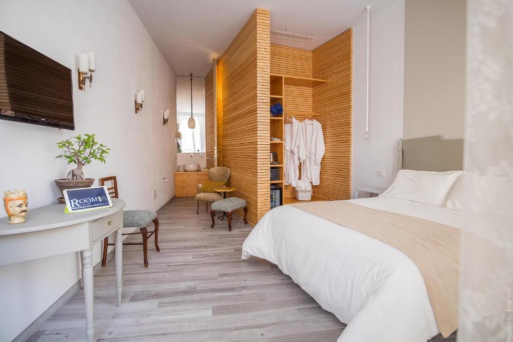 a bedroom with a large bed and a desk and chair at Room 55 in Noto