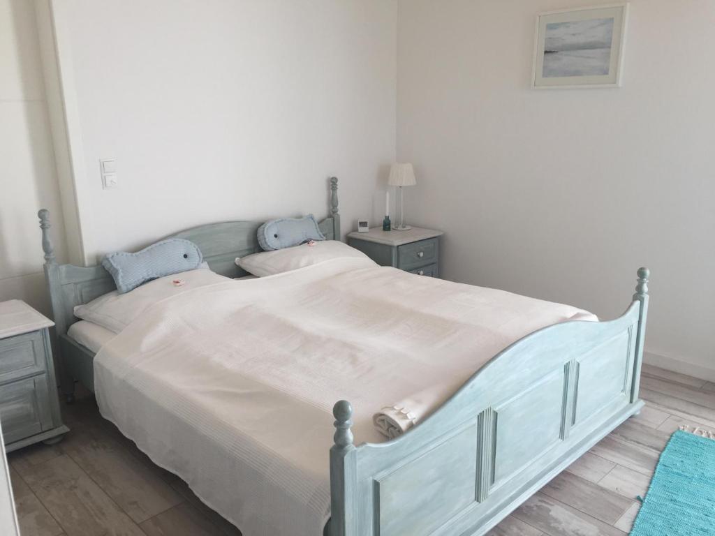 a bedroom with a large bed with white sheets at Meeresbrise in Laboe