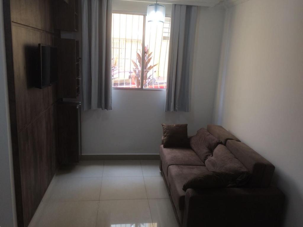 ein Wohnzimmer mit einem Sofa und einem Fenster in der Unterkunft Excelente apartamento em Belo Horizonte in Belo Horizonte