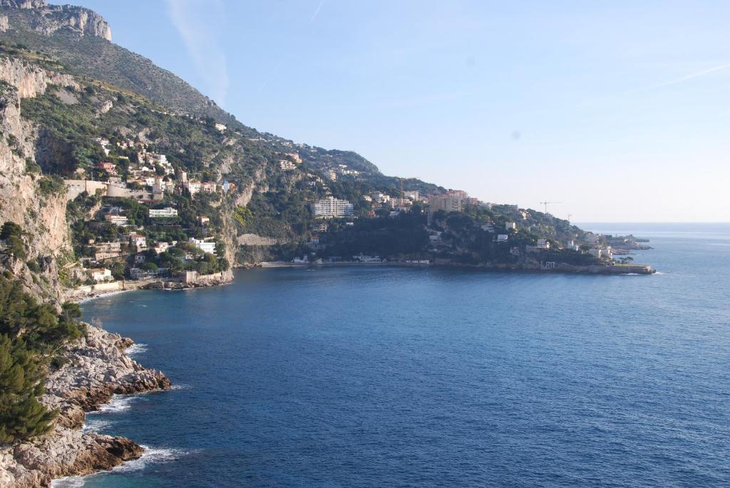 an island with houses on the side of the water at Hotel Miramar in Cap d'Ail