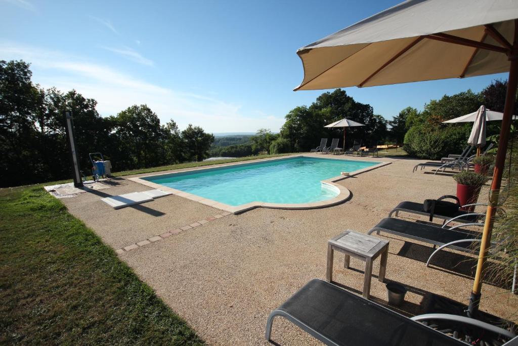 a swimming pool with chairs and an umbrella at Le Domaine des Fargues in Sainte-Foy-de-Longas
