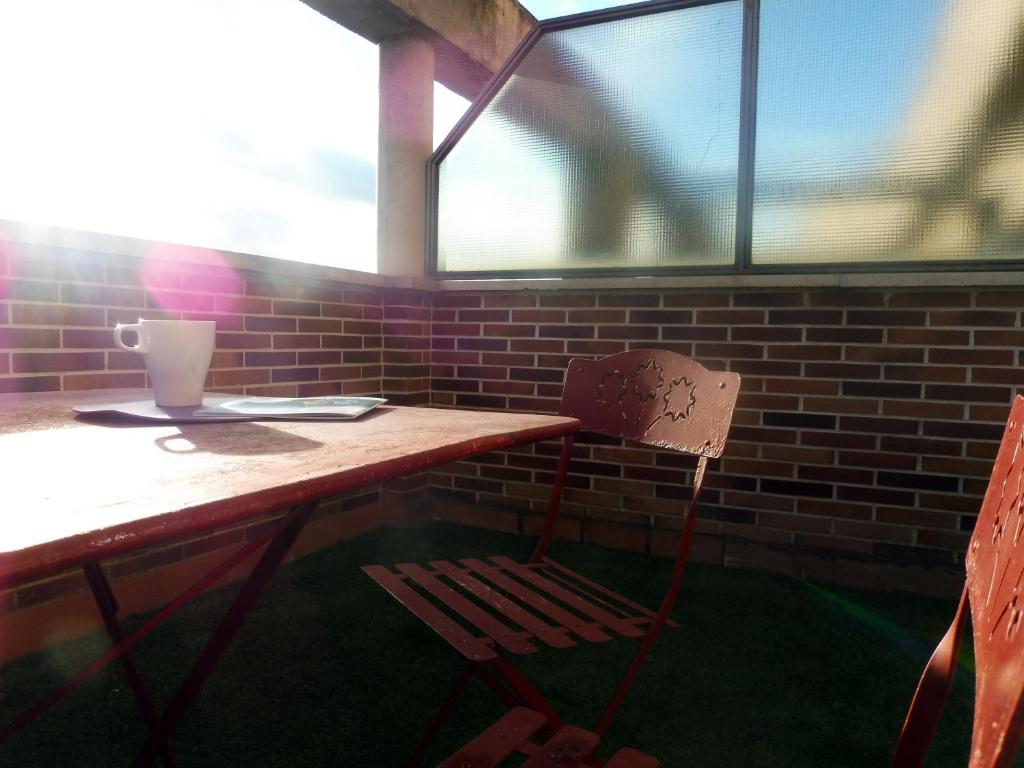 a wooden table with a chair next to a brick wall at Ático en Pamplona in Barañáin