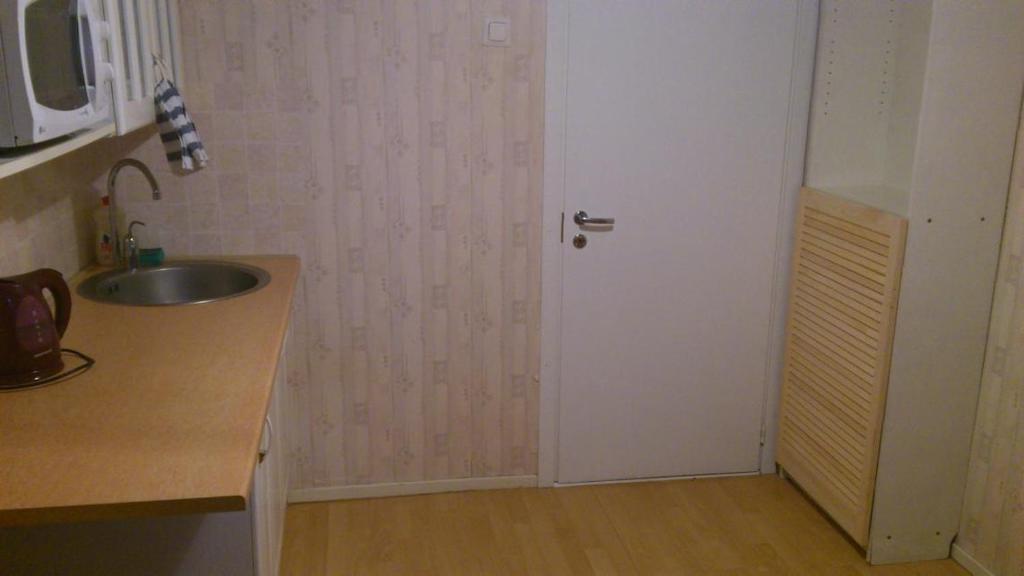 cocina con puerta blanca y fregadero en Economy Baltics Apartments - Uue Maailma 19, en Tallin