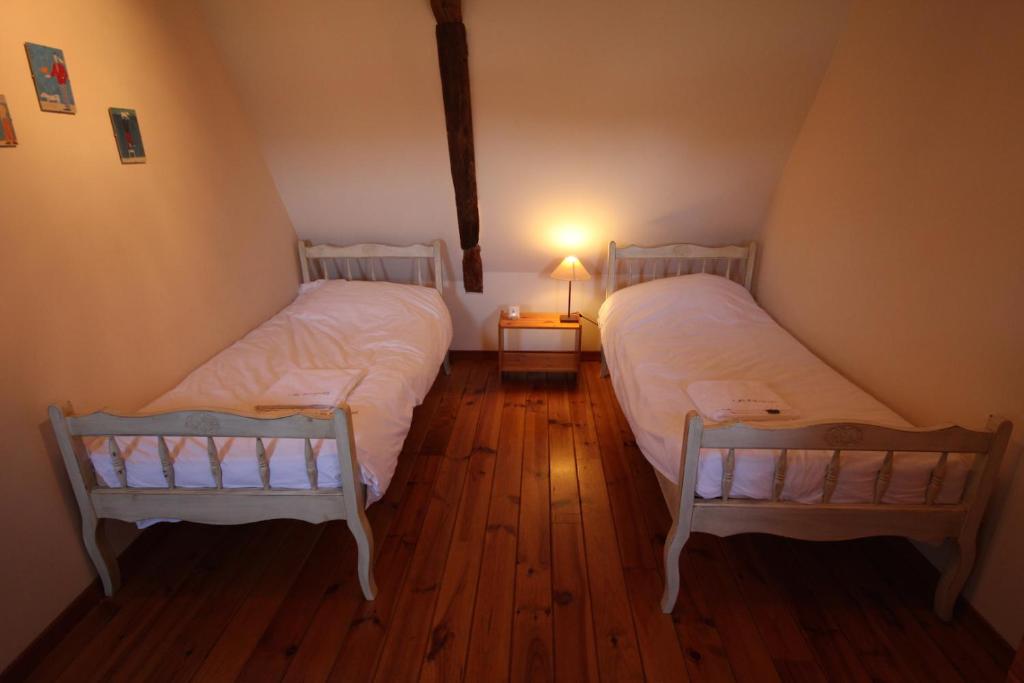 two twin beds in a room with a lamp at Le Domaine des Fargues in Sainte-Foy-de-Longas