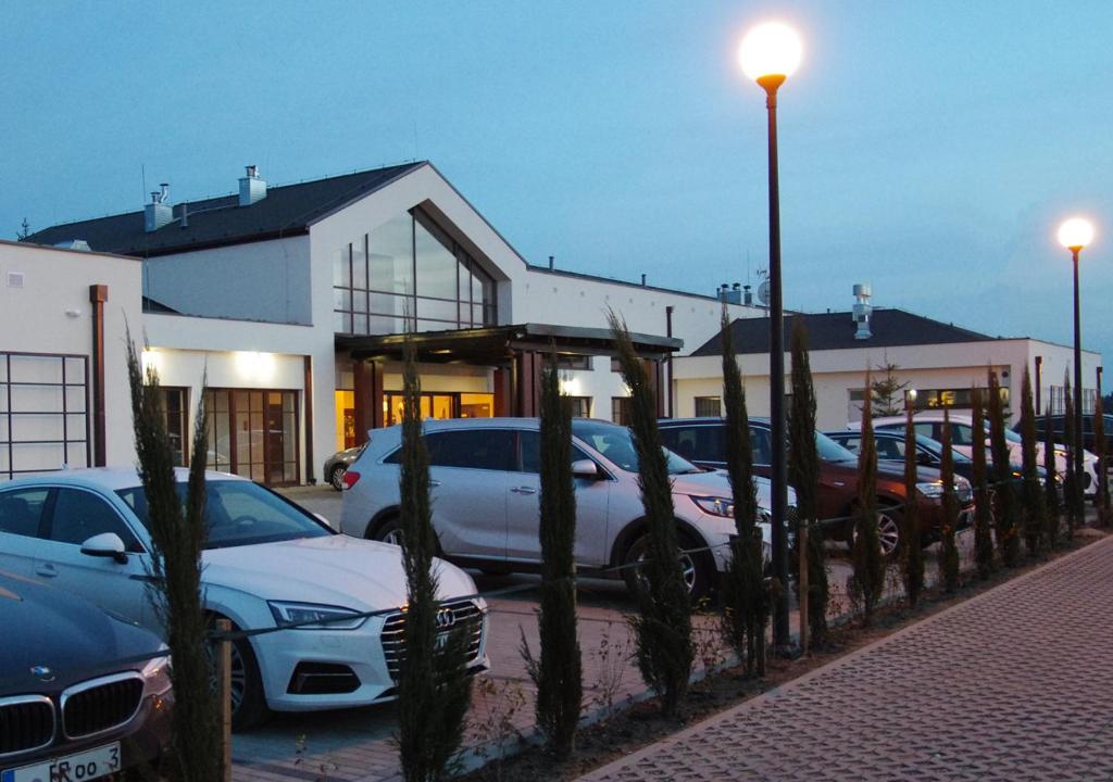 parking z samochodami zaparkowanymi przed budynkiem w obiekcie M Club Hotel | Lubie Resort w Drawsku Pomorskim