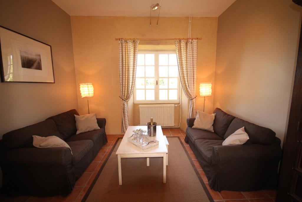 a living room with two couches and a coffee table at Le Domaine des Fargues in Sainte-Foy-de-Longas