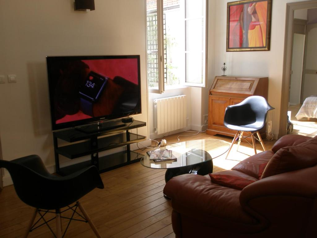 un salon avec un canapé et une télévision à écran plat dans l'établissement Rochais, à La Rochelle