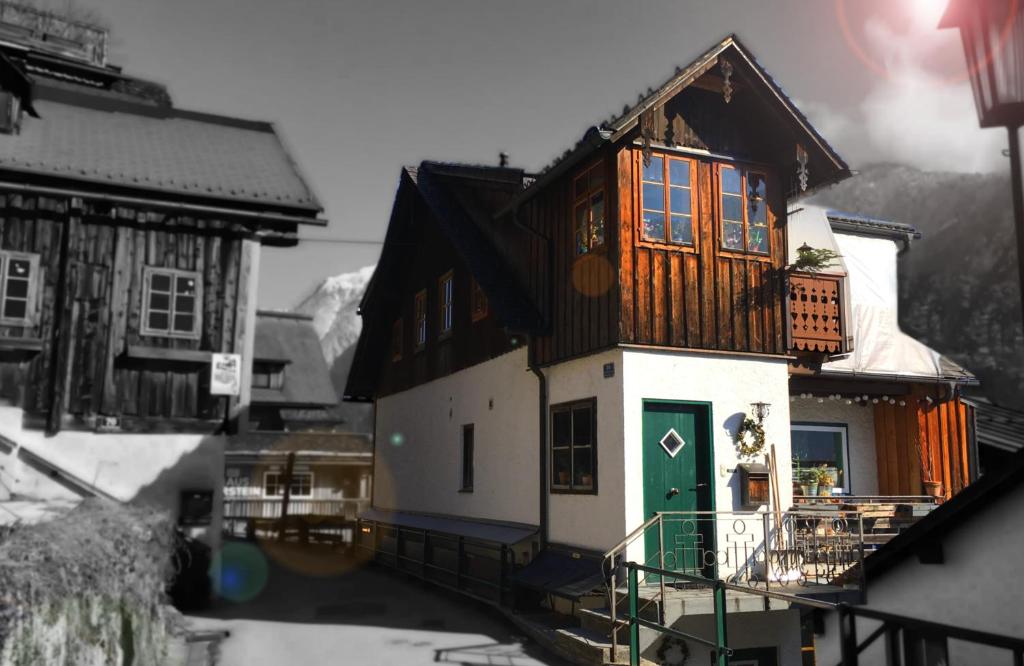 uma pequena casa com uma porta verde num edifício em PinkDeer em Hallstatt