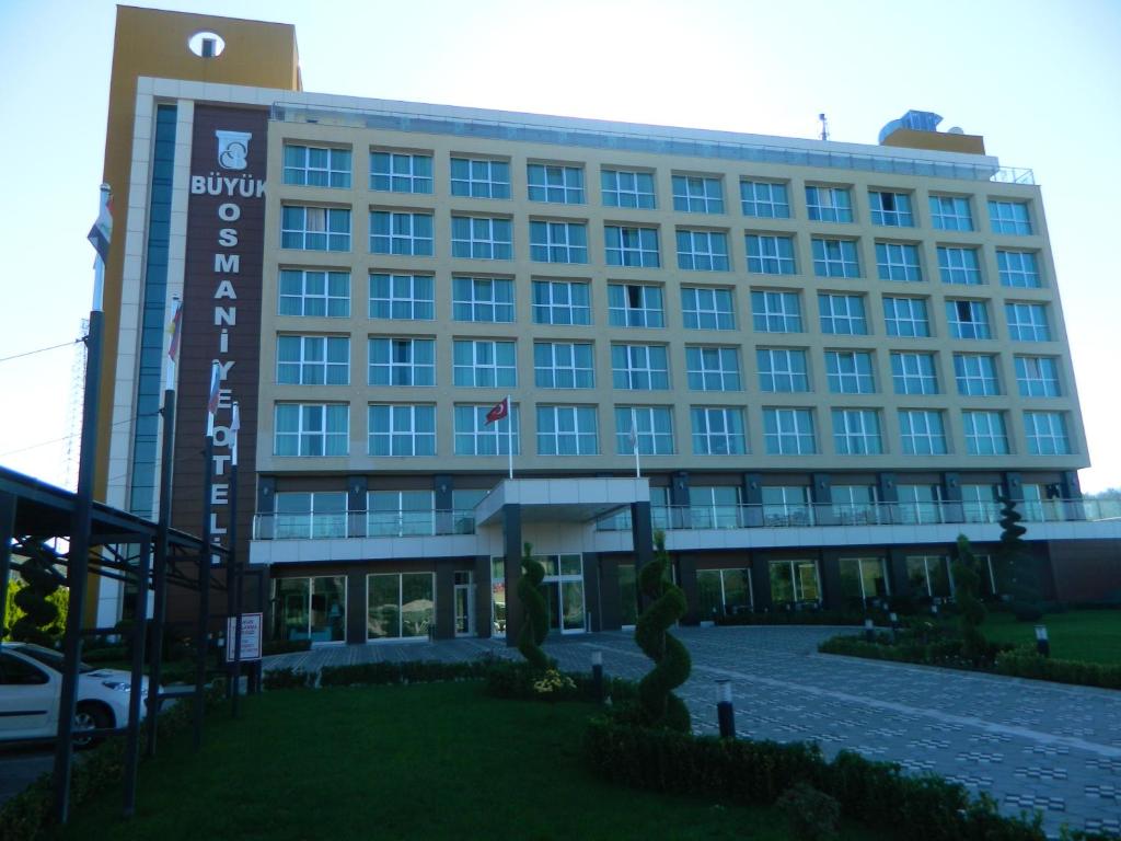 a large building with a sign in front of it at Buyuk Osmaniye Hotel in Osmaniye