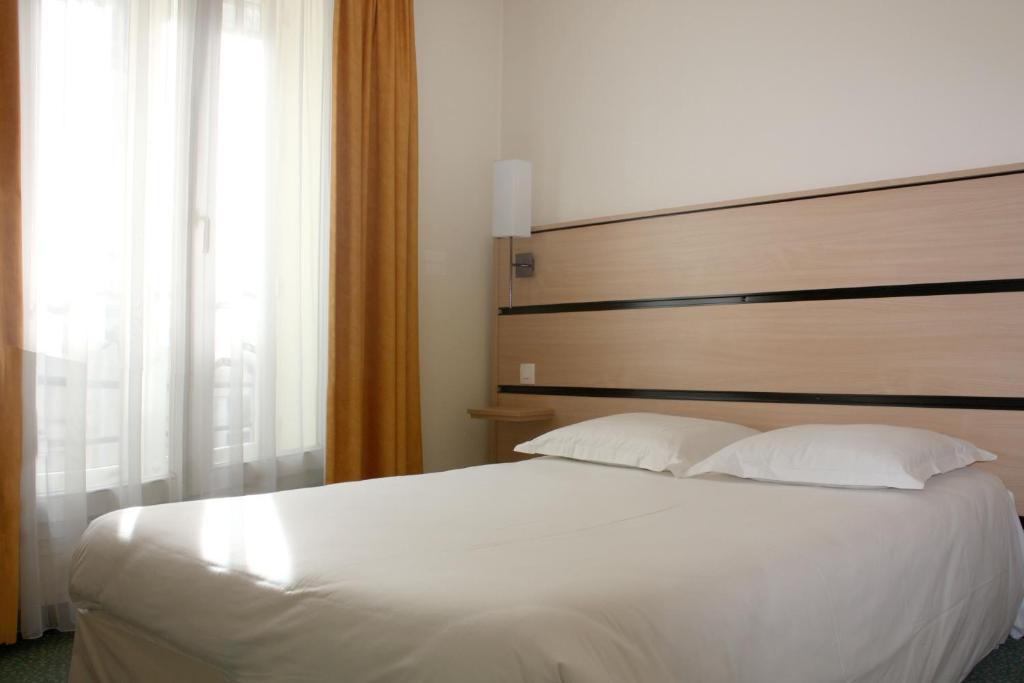 A bed or beds in a room at New Hotel Saint Lazare