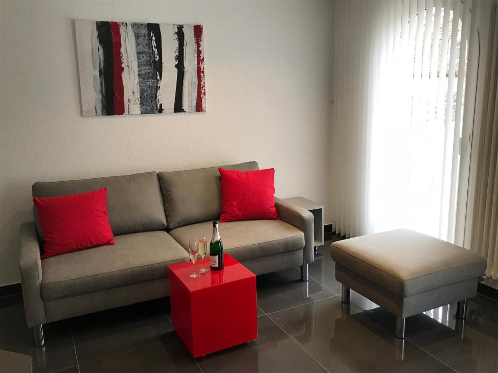 a living room with a couch and a red table at Luxus-Appartement im Herzen der Stadt in Bad Kreuznach