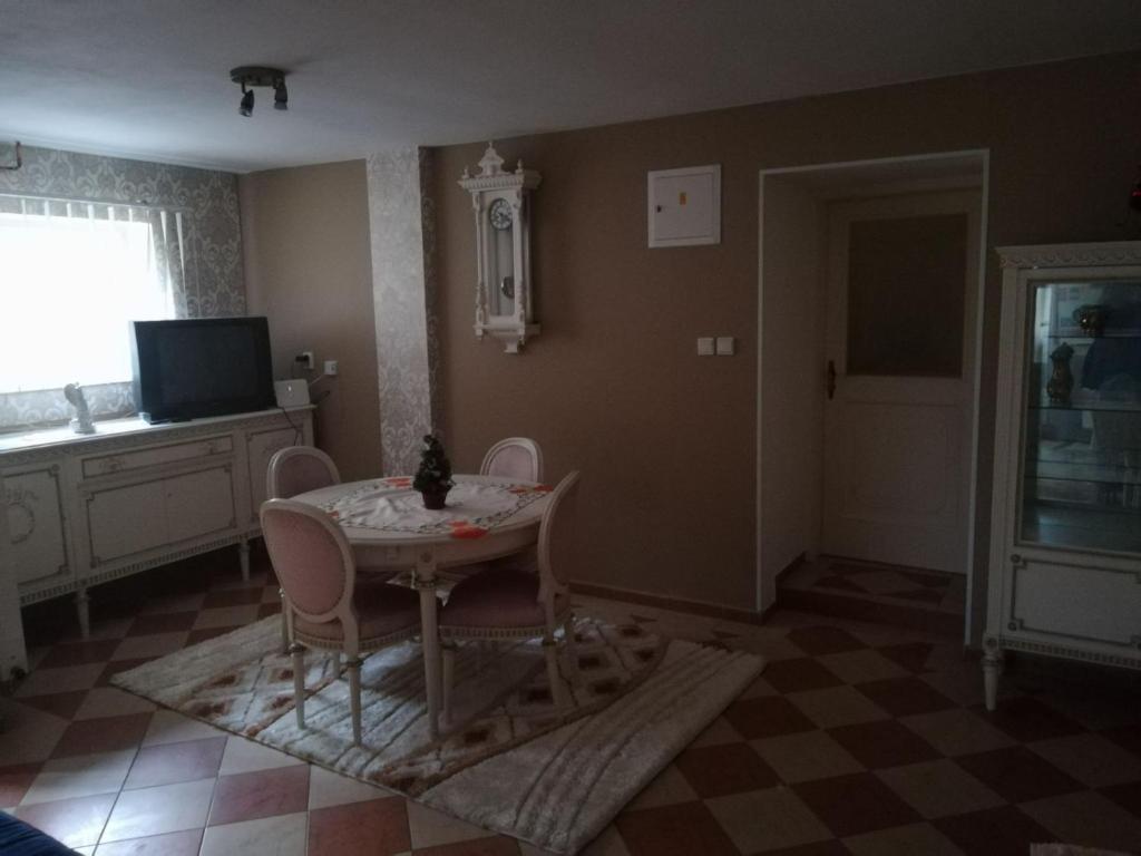 a living room with a table and chairs and a television at Ubytovanie Tri sestry in Hrabušice
