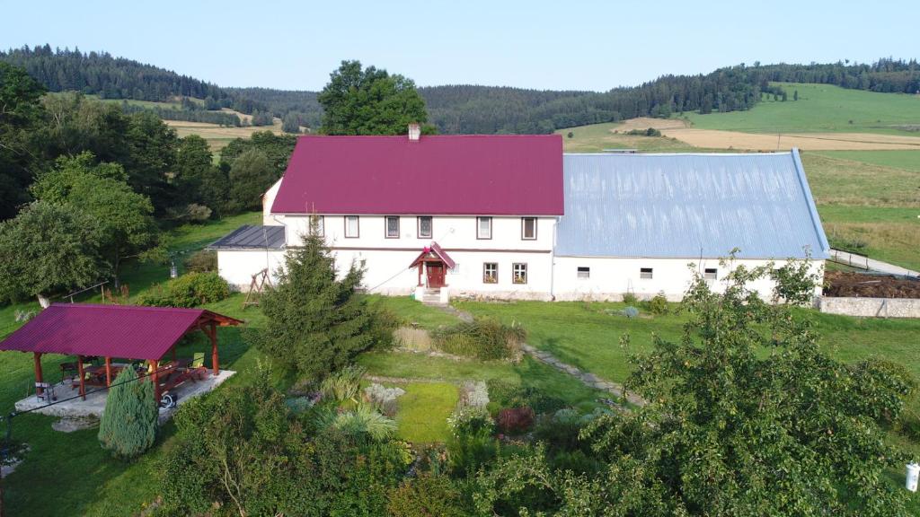 widok z powietrza na białą stodołę z fioletowym dachem w obiekcie Pod kasztanem gospodarstwo agroturystyczne w Stroniu Śląskim