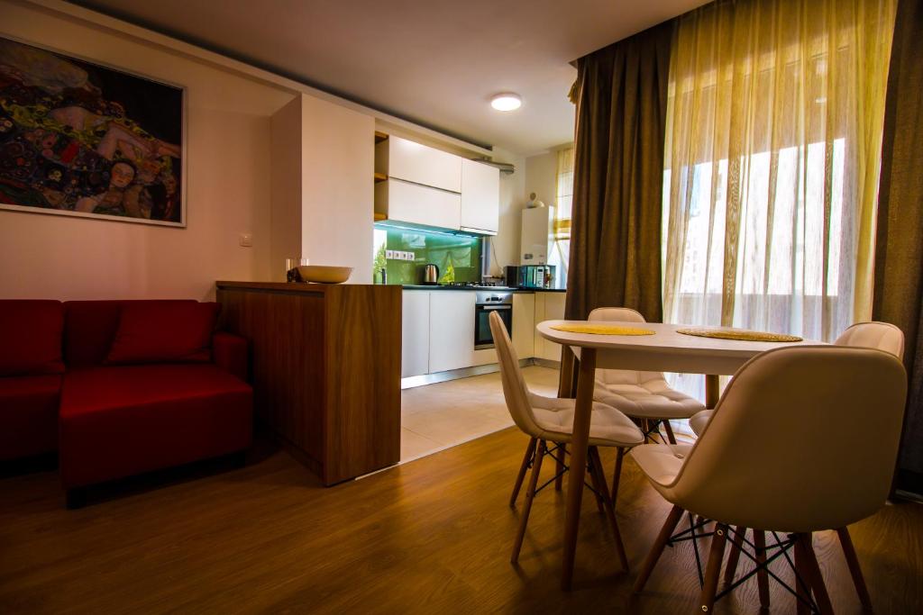 uma cozinha e uma sala de estar com mesa e cadeiras em Top Trio Residence em Bucareste