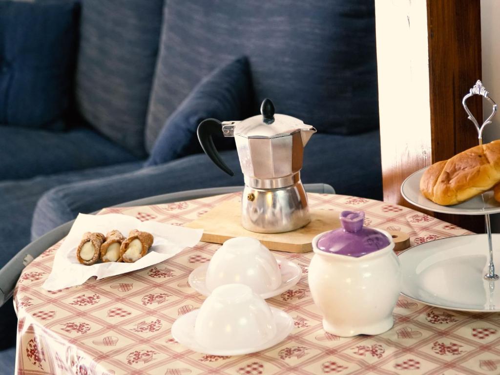 un tavolo con caffettiera e pasticcini di Appartamento Taranto a Taranto