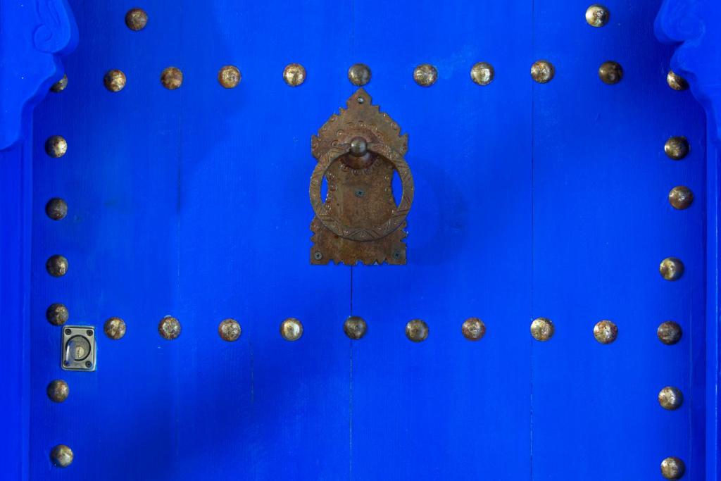 a blue wall with a metal door with gold rivets at Riad SPA &quot;Les Portes de l&#39;Orient&quot; TOURS in Tours