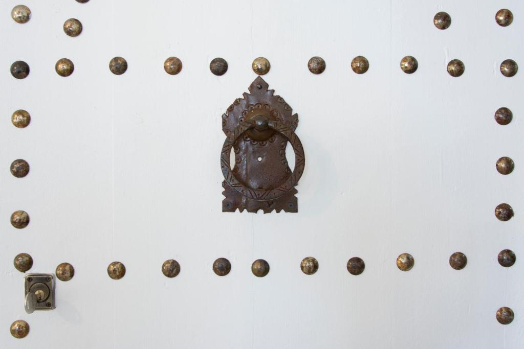 a group of bronze buttons on a white wall at Riad SPA &quot;Les Portes de l&#39;Orient&quot; TOURS in Tours