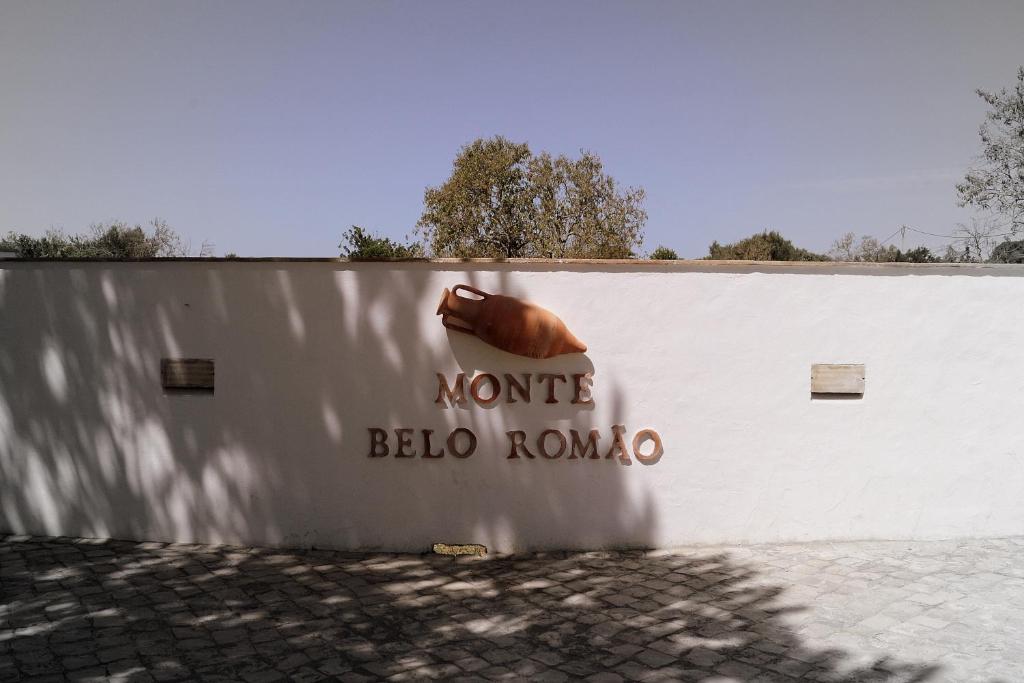 een witte muur met een bord waarop staat: nunta beta roma bij Monte Belo Romão in Olhão