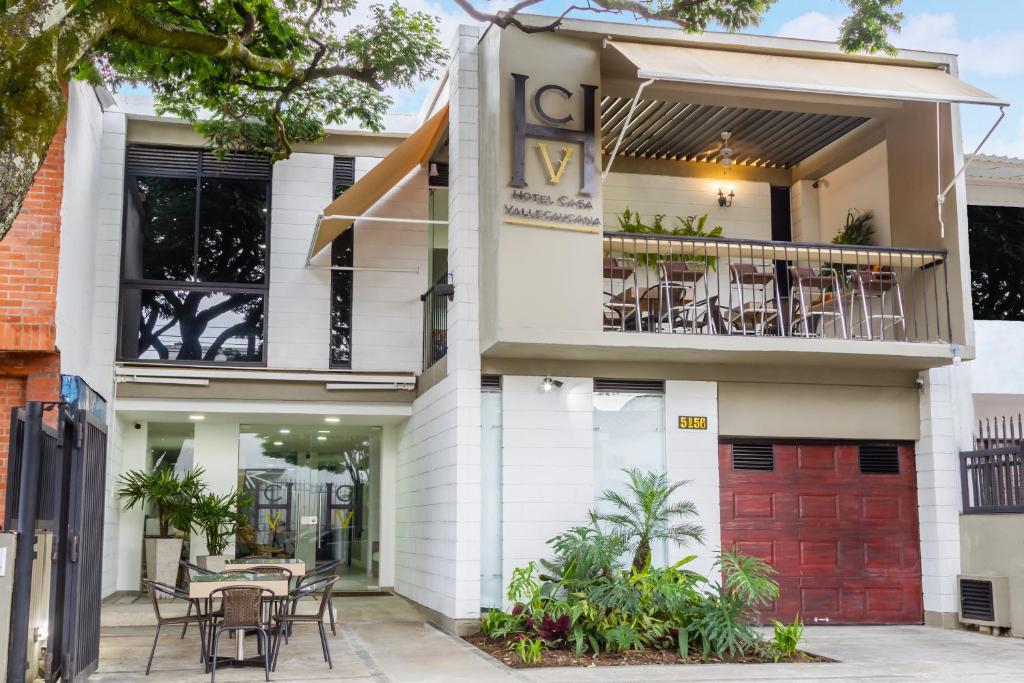 a white building with tables and chairs on the balcony at Hotel Casa Vallecaucana in Cali