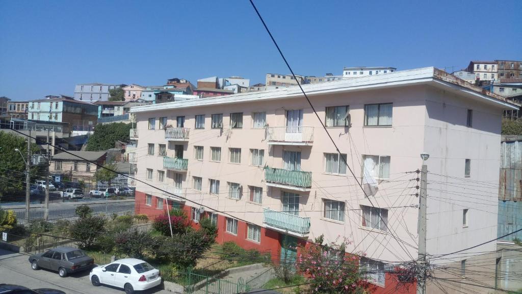 un edificio de apartamentos con coches estacionados frente a él en Apartamento Valparaiso, en Valparaíso