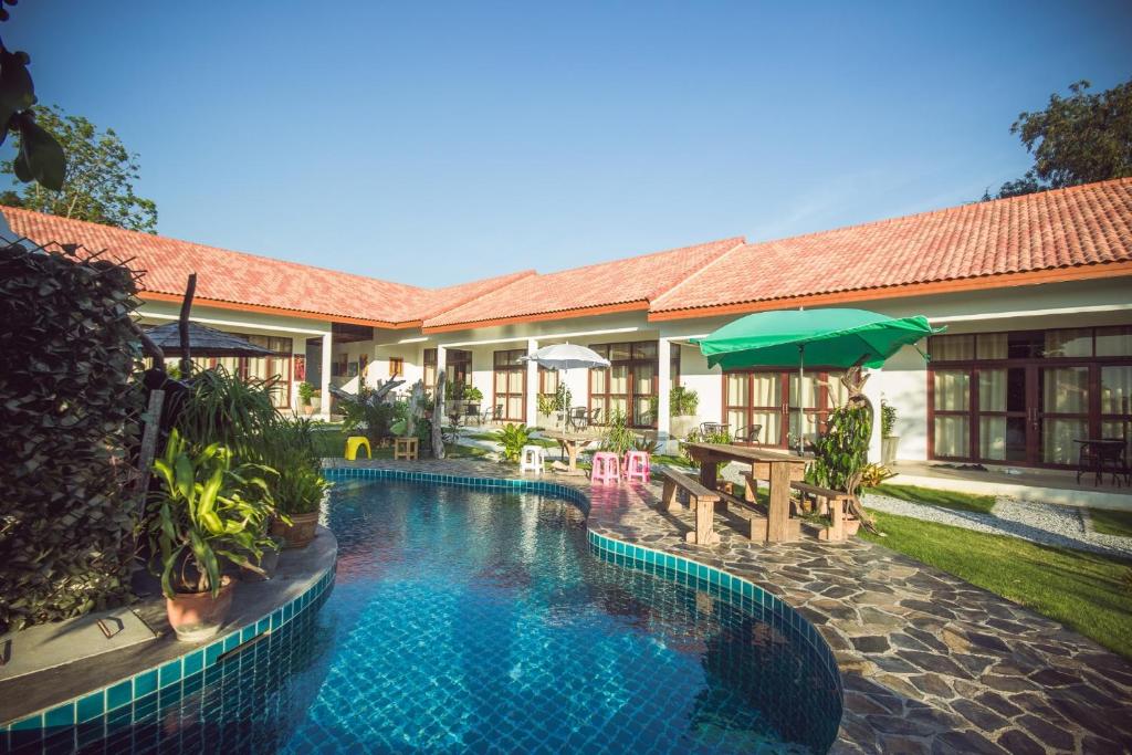 uma piscina em frente a uma casa em Tree Roots Retreat em Rayong